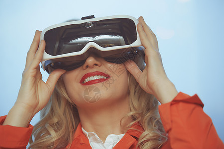 身穿虚拟现实头盔的妇女互动性创新游戏快乐视频模拟器乐趣工具技术耳机背景图片