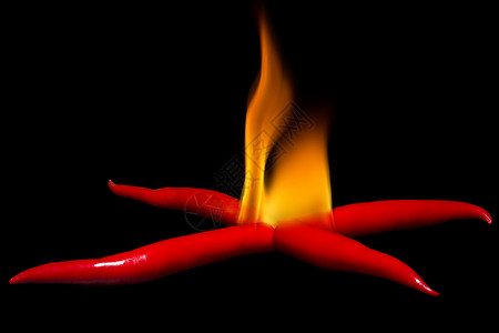 用辣椒放火 暗底的辣椒堆放火背景图片