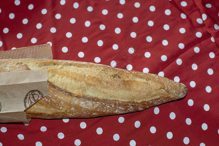 红白波尔卡圆点织物上的包面包背景图片