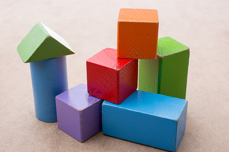 棕色背景上的多彩建筑块商业立方体玩具建筑童年木头团体活动教育积木背景图片