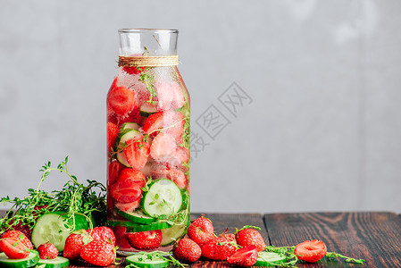 灌满了草莓 黄瓜和Thyme的水饮食福利叶子排毒草本植物酒精浆果食物香料水果背景图片