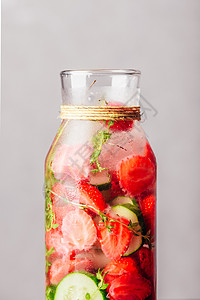 灌满了草莓 黄瓜和Thyme的水排毒草本植物苏打青菜活力瓶子香料酒精输液饮料背景图片