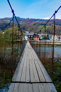 一个山村的旧悬吊桥横跨河面背景图片