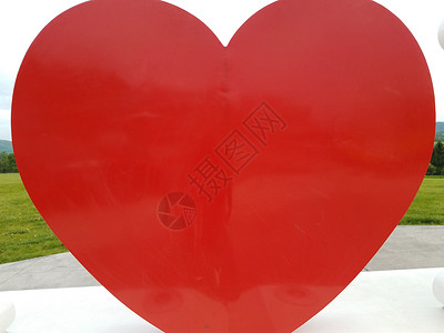 户外白色平台上的大红红心形状背景图片