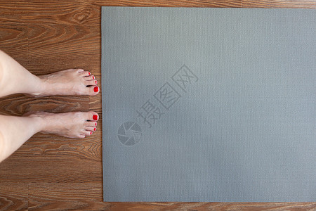 女人赤脚站在地板上 在体操垫前 S高清图片