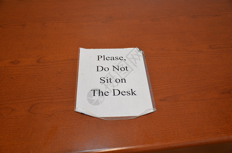 请不要坐在木头桌上的字牌上背景