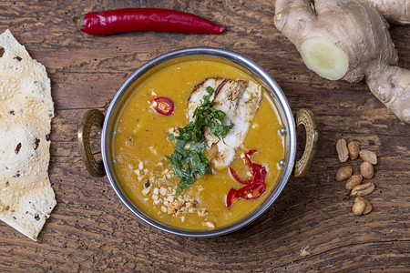 花生猪脚汤在黄铜碗里喝印度的木利加塔尼汤奶油香菜黄色乡村花生文化午餐辣椒食物扁豆背景