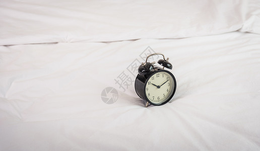 早上8点在床上的黑闹钟闹钟工作警报小时倒数圆圈钟声手表床单小憩睡觉高清图片素材