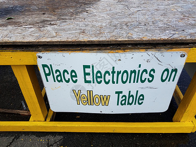 将电子设备放在黄色表格牌子上 在回收中心加填表背景图片