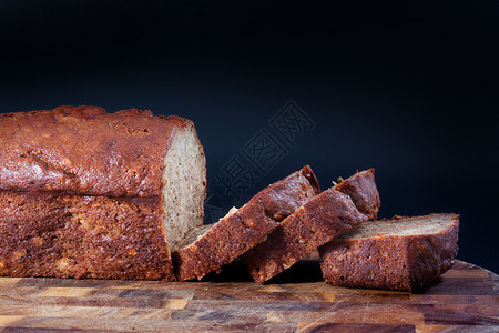 木板上美味的香蕉蛋糕香蕉面包甜点黑色木头早餐背景图片