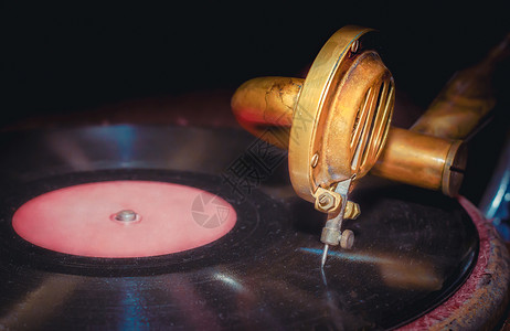 黑乙烯唱片和老古老的留声录音片段特写音乐播放器黄色留声机光盘复古播放器黑胶音乐电唱机金属背景图片