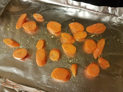 金属叶子烘烤盘上的橙红胡萝卜片食材挫败萝卜午餐蔬菜托盘背景图片