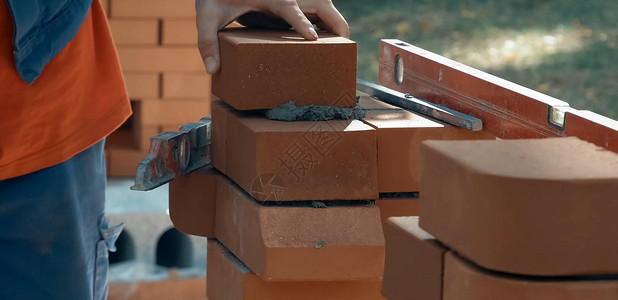 一个人建砖墙 布瑞克把解决方案放上去了 砖房的建造工地砂浆技术安全帽水泥房子活动建筑学工作石工背景