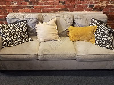 灰沙发或带有黑白和黄色枕头的沙发背景图片