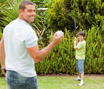 快乐的父亲和儿子在打棒球友谊男性享受生活公园微笑孩子幸福手套男生家庭高清图片素材