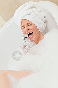 迷人的女人洗个澡 头上戴毛巾卫生女孩女性笑脸微笑气泡温泉护理洗澡女士背景图片