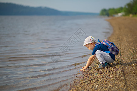小男孩在大河里亲手摸到水面男生高清图片素材