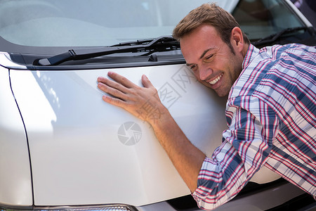 年轻人拥抱他的车汽车喜悦倾斜服装快乐运输休闲顾客男人微笑男性高清图片素材