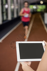 使用数字平板电脑的培训员 而男子则在进行跑步锻炼体质教练培训师娱乐技术讲师网络专注健身房竞技背景图片