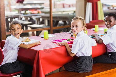 儿童在学校食堂休息时间吃午餐的儿童人数女孩学生蔬菜孩子们食物女性桌子制服女学生教育饥饿的高清图片素材