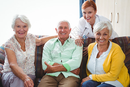 看着摄影机的退休老人微笑的肖像医疗女士闲暇女性技术制服幸福快乐电脑触摸屏老年人高清图片素材