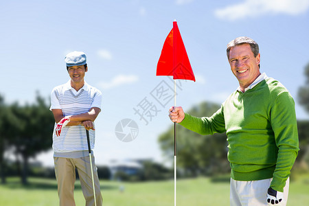 男子拥有高尔夫俱乐部的复合形象公园树木男性活力高尔夫球高尔夫球服老年爱好蓝天娱乐背景图片