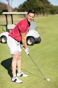 微笑的年轻人打高尔夫球的肖像高清图片