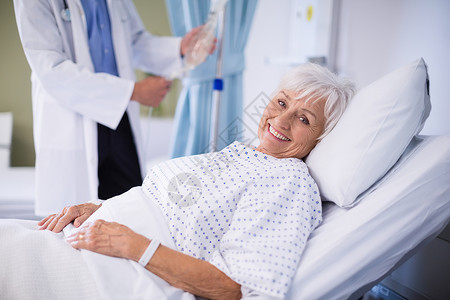 高级病人躺在床上临床服务女性医生医师盐水医院疾病点滴外科背景图片