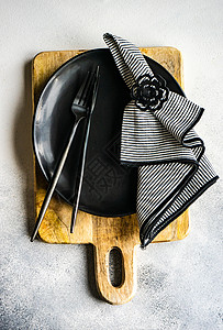 最小化黑白黑桌设置黑与白盘子银器制品食物陶瓷餐具灰色餐巾石头背景图片