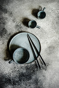 亚洲风格的表格设置石头刀具盘子银器餐具环境黑色筷子桌子木板背景图片