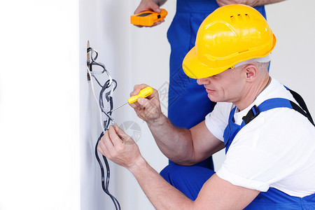 电工为墙套接缝安装电线接线高清图片素材