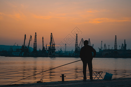 渔夫在日落黄金时分 在港口码头的船坞做轮椅高清图片