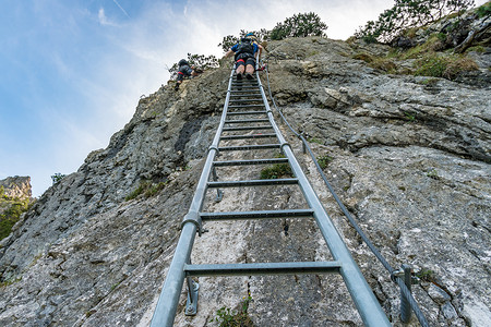 徒步和爬上泰格尔堡蓝色压力铁索草地高山登山者运动海岸悬崖全景背景图片