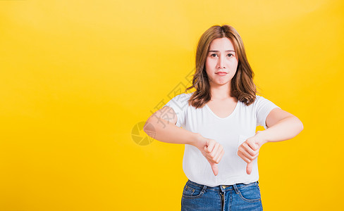 女人不快乐 一个消极的手势 显示手指拇指向下黄色女士失败黑色女性女孩工作室黑色的高清图片素材
