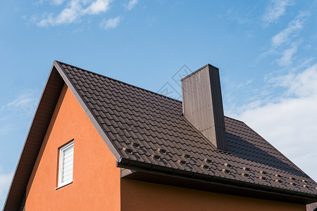 蓝屋顶房子覆盖有瓷砖效果 PVC 涂层棕色金属屋顶板的现代屋顶建筑技术住宅天空房子橙子建筑学卵石陶瓷平铺背景