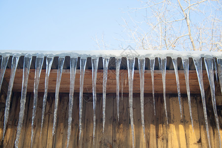 木屋顶的冰柱建筑学天空季节蓝色水晶天气建筑房子冻结危险背景