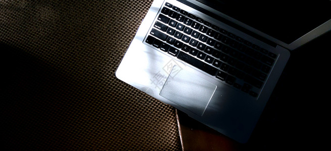 沙发上的笔记本电脑钥匙自由职业者键盘会议屏幕商业疾病棕色房子宏观背景图片