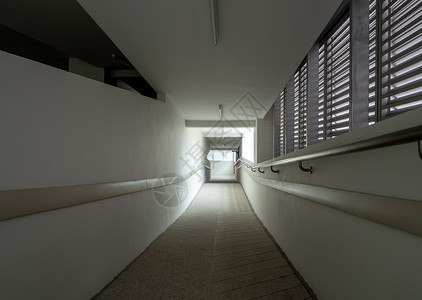 大楼走廊出口处的灯光照亮大厅白色地面阴影入口隧道黑色门厅人行道建筑背景图片