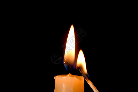 蜡烛的火焰和黑色背景的火柴背景图片