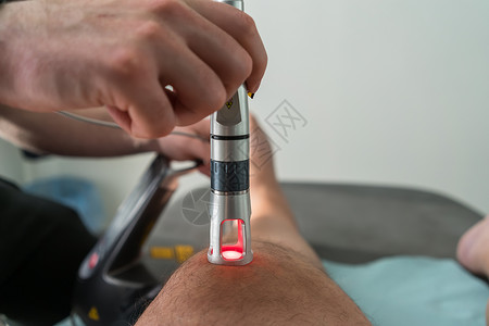 用来治疗疼痛的膝盖激光疗法病人按摩功能性医生脊椎皮肤海浪男人背痛震惊背景图片