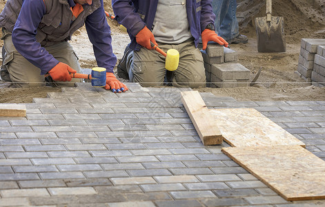 工人们在人行道上铺砖头 把瓷砖放在线上阳台石匠修理锤子建设者石头小路职场工人工作手高清图片素材