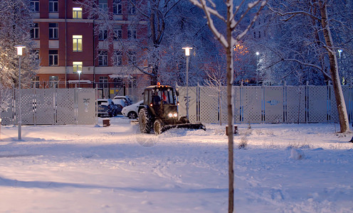 冬天魔法清理道路上的雪驾驶工作公园车轮机械降雪运输平地机拖拉机城市背景