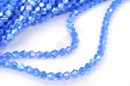 白色背景上美丽的浅蓝色玻璃闪光水晶 Isoalted 珠 用于 DIY 珠宝商礼物配饰石头爱好钻石火花蓝色手镯装饰工艺背景图片