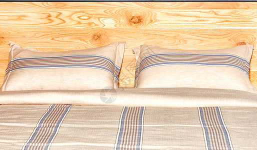 木质床头板背景上美丽米色棉织物的床单质地高清图片