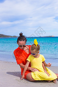 热带沙滩度假期间的小女孩和快乐妈妈母亲家庭海洋孩子女士幸福女孩海岸线享受成人微笑高清图片素材