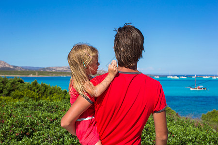年轻的父亲和小女孩 享受着美丽的绿海景色的青春旅游孩子假期游客蓝色海滩女儿父母风景爸爸绿松石高清图片素材