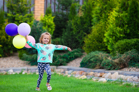玩气球的小女孩快乐的小女孩在户外玩气球投掷庆典跑步草地阳光女性金发生活女士女孩背景