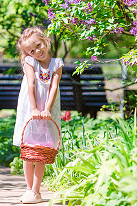 春天的花园 春天的花朵 可爱的小女孩和郁金香 温暖的日子里 在盛开的花园里提着篮子的可爱孩子露天高清图片素材