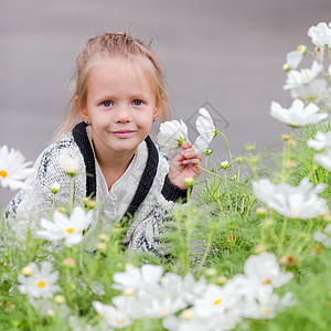 可爱的小可爱女孩 在户外闻着多彩鲜花的香味空地童年玫瑰自由女儿女性叶子植物喜悦露天纯真高清图片素材