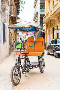 格瓦拉古巴出租车自行车停在多彩殖民房屋前的古巴计程车背景
